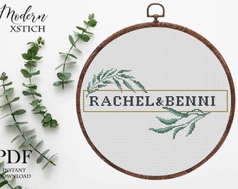 Puede incluir: Un patrón de punto de cruz con un marco dorado y hojas verdes que rodean el texto "RACHEL & BENNI".