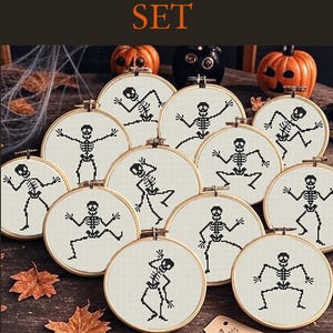 Puede incluir: Un conjunto de doce diseños de esqueletos bordados en aros de madera. Cada aro presenta un esqueleto en blanco y negro sobre un fondo crema. El texto "12 SKELETONS SET" está en la parte superior. Calabazas y hojas de otoño en el fondo.