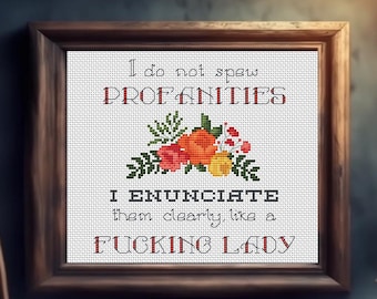 May include: Cross-stitch artwork in a wooden frame. The white fabric features a floral design and the text: "I do not spew PROFANITIES. I ENUNCIATE them clearly, like a FUCKING LADY."