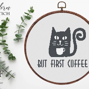 Pode incluir: Padrão de ponto cruz com um gato preto segurando uma xícara de café, com o texto "BUT FIRST COFFEE" abaixo. O design está em um bastidor de bordado de madeira. As palavras "Modern XSTICH" e "PDF Instant Download" também são visíveis.