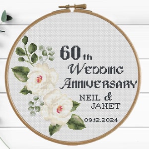 May include: White embroidery hoop with a floral design and the text "60th Wedding Anniversary Neil & Janet 09.12.2024"