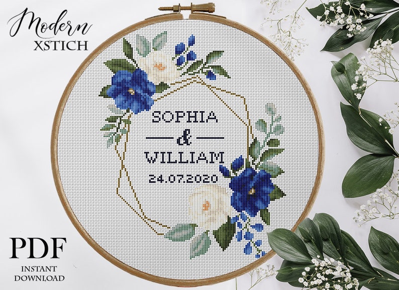 Pu&ograve; includere: Schema di punto croce con una cornice geometrica dorata decorata con fiori blu e bianchi, il testo "Sophia & William 24.07.2020" e le parole "Modern Xstitch" in alto.