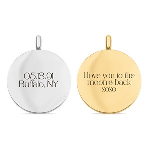 May include: Two circular metal pendants with bails. The silver-toned pendant is engraved with 05.13.91 and Buffalo, NY. The gold-toned pendant is engraved with the text I love you to the moon & back and XOXO. Both pendants have a smooth finish.