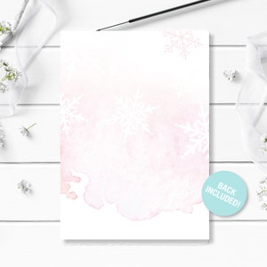 May include: A blank white card with a watercolor background in shades of pink and blue. The card is decorated with white snowflake designs. The text "Back Included!" is printed on a blue circle sticker in the bottom right corner.