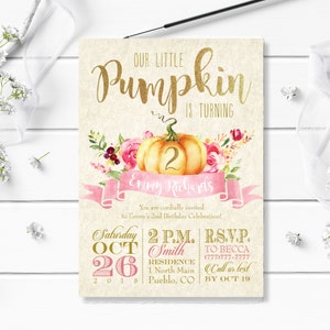 以下が含まれることがあります： 「Our Little Pumpkin is Turning 2」のテキストが入った誕生日招待状。水彩画のカボチャ、ピンクのバナー、花のアクセントが特徴です。詳細には、日付、時間、場所、RSVP情報が含まれます。