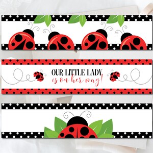May include: Three rectangular banners with ladybug designs. The top and bottom banners feature red ladybugs with black spots and antennae, set against a white background with black polka dots. The middle banner reads "OUR LITTLE LADY is on her way!" in red.