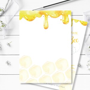 May include: A white card with a yellow honeycomb pattern and dripping honey design. The text "Celebrate Bee" is printed on the card.