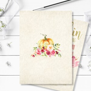 May include: Watercolor design of a pumpkin with a green stem and floral arrangement of pink, red, and cream-colored roses and leaves. The pumpkin is on a cream-colored card. A second card is partially visible with gold text.