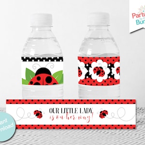 May include: Two clear water bottles with ladybug-themed labels. One label features a ladybug design with green leaves, the other has a floral pattern with ladybugs. A matching banner reads "OUR LITTLE LADY IS ON HER WAY!"