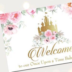 Puede incluir: Un cartel de bienvenida con un castillo dorado y flores rosas. El texto dice "Bienvenido a nuestro Baby Shower Once Upon a Time".