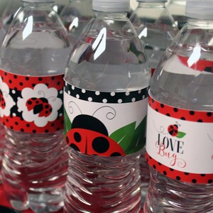 May include: Clear plastic water bottles with decorative labels. The labels feature ladybug designs, red polka dots, and the words "Love Bug". Some labels have a black and white polka dot border.