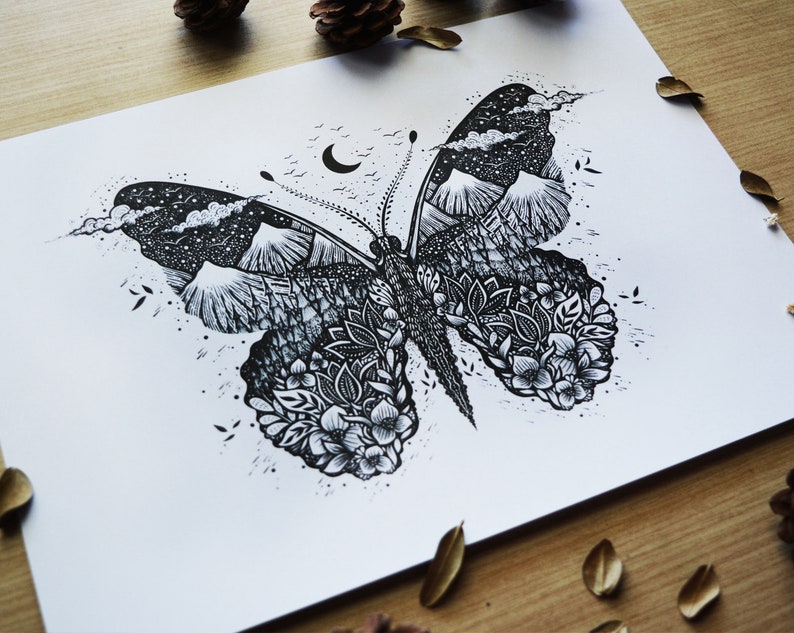 May include: Black and white ink drawing of a butterfly with a mountain range and starry sky inside the wings. The butterfly is surrounded by a floral design.