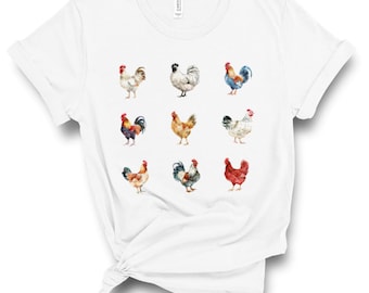 Puede incluir: Camiseta blanca con un patrón de nueve gallos de acuarela en varios colores y poses.