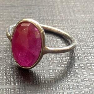 Puede incluir: Un anillo de plata con una gran piedra preciosa rosa de forma ovalada.
