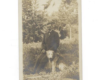 The Intellectual. Undated RPPC portrait of a glasses-wearing man posed in nature with a wolfhound.
