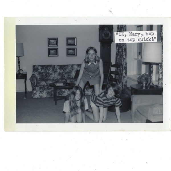 Hop on top! 1970s vintage snapshot of 3 girls forming a pyramid in a living room.