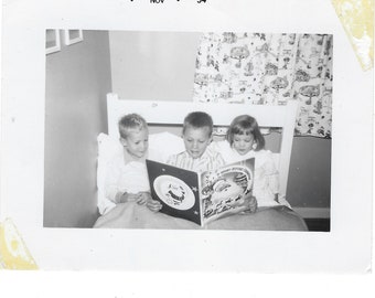 Story Time! 1950s vintage photo of a boy reading The Night Before Christmas to his siblings.