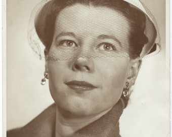 Veiled. 8x10 undated promotional photo of a woman modeling a hat. John Peterson, Chicago.