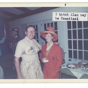 May include: Vintage photograph of a man and a woman at a party. The man wears a beige shirt, a decorative bra, and a grass skirt. The woman wears a red blazer and a matching hat. Text in the image reads, "I think Alan may be Hawaiian!"