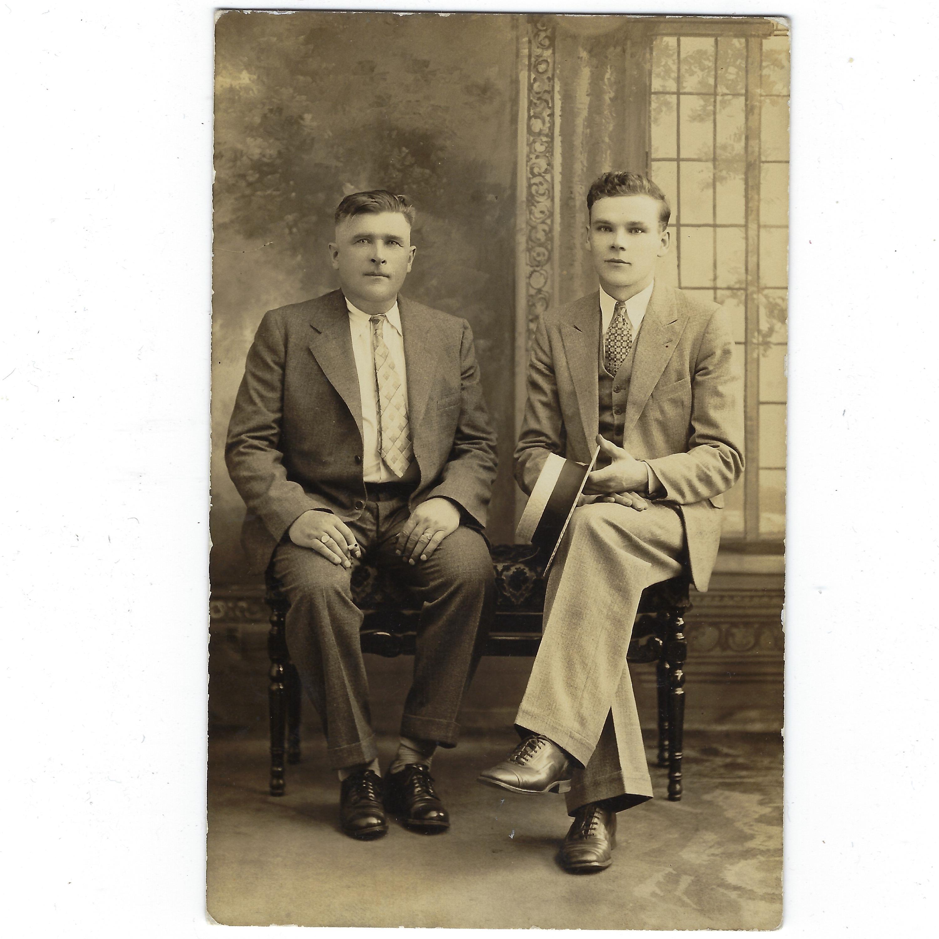 Father and Son? Undated RPPC portrait: An older man and a younger man. One is holding a cigarette, the other is holding a boater hat.