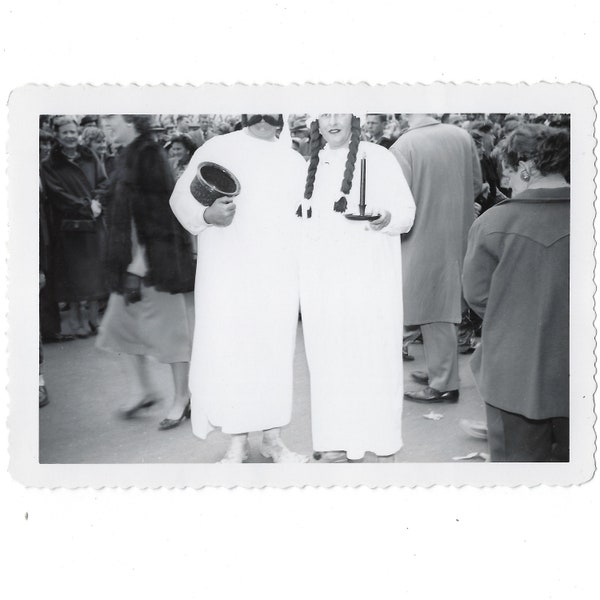 Heads cut off. Undated vintage snapshot of a couple on the street in nightshirt costumes.