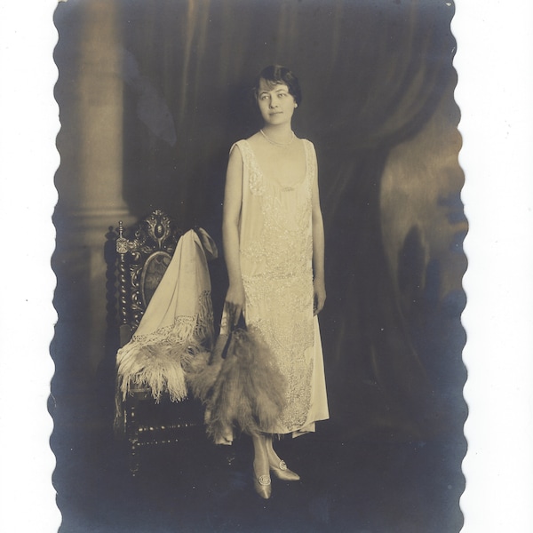 Fashion Plate: Larger 6 1/2" x 9 1/4" photo of a flapper-era woman in a beaded dress with feather fan.