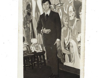 Cosmic Baby. Undated photo of a fashionable young man posed in front of a mural.