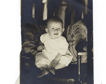 Spooky baby! Undated original photo of a baby propped against embroidered pillows.