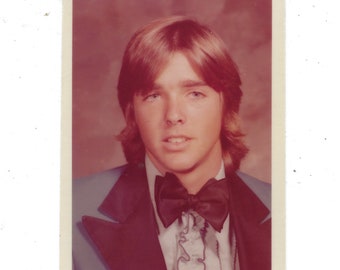 Feathered hair. Undated yearbook photo of a handsome young man in a powder blue tuxedo.