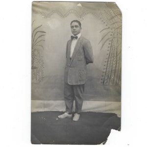 Bow tie. Vintage photo of a handsome man in a suit and tie posed against a painted backdrop.