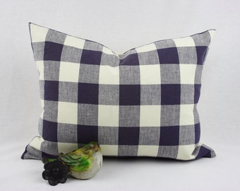 May include: A navy blue and white checked cushion with a white background and navy blue squares. The cushion is made of a soft, woven fabric.