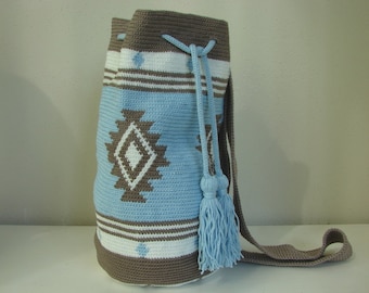 May include: A crocheted drawstring bag with a geometric pattern in shades of brown, white, and light blue. The bag has a long strap and a tassel.