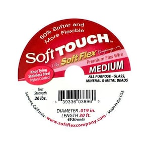 Op de afbeelding: Een spoel rode Soft Touch van Soft Flex Company Premium Flex Wire in medium formaat. De draad is geschikt voor alle doeleinden met glas, mineraal en metalen kralen. De spoel is 9,14 meter lang en heeft een diameter van 0,48 cm. De draad is gemaakt van roestvrij staal en is nylon gecoat. De spoel is gemaakt in de VS.