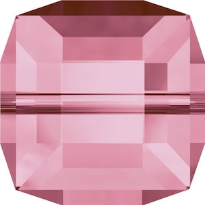 Könnte beinhalten: Eine rosa facettierte Glasperle in quadratischer Form.