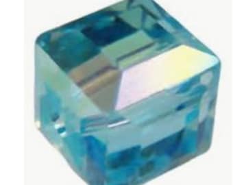 May include: A light blue square crystal bead with a faceted design.