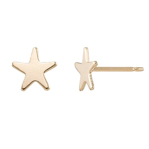 May include: A pair of gold star stud earrings. The earrings are small and delicate, and they would make a great gift for a friend or loved one.