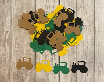 May include: A collection of colorful tractor cutouts in shades of brown, yellow, green, and black. The cutouts are scattered on a light wood-grain surface. The tractors are a simple, two-dimensional design, suitable for crafting or party decorations.