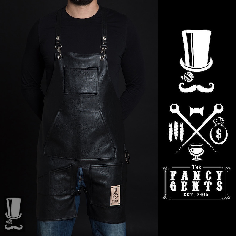 May include: Black leather apron with adjustable straps, two large pockets, and a smaller pocket on the front. The apron has a small patch with a logo that says "The Fancy Gents Est. 2015".