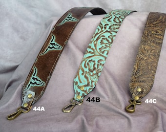 May include: Three brown leather straps with different embossed designs. The strap labelled 44A has a turquoise background with a repeating pattern of bull skulls. The strap labelled 44B has a turquoise background with a floral pattern. The strap labelled 44C has a brown background with a floral pattern.