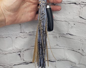 May include: A blue and tan leather tassel keychain with a black and silver key fob.