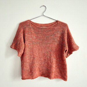 K&ouml;nnte beinhalten: Ein kurz&auml;rmeliger, gestrickter Pullover in Rost- und Braunt&ouml;nen mit lockerer Passform.