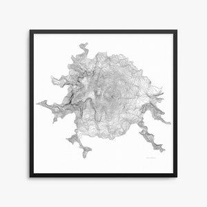May include: Black framed print featuring a detailed topographic map of Mount Shasta. The map is rendered in grayscale, showcasing contour lines that depict the mountain's elevation and terrain. The artwork is set against a white background.