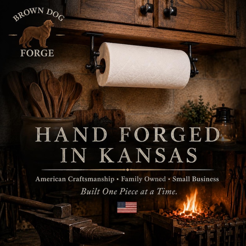Może przedstawiać: Czarny metalowy uchwyt na ręcznik papierowy zamontowany pod drewnianą szafką. Obraz zawiera tekst BROWN DOG FORGE, HAND FORGED IN KANSAS, American Craftsmanship, Family Owned, Small Business, Built One Piece at a Time oraz flagę USA.