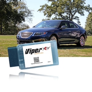 May include: A blue car parked on a grassy lawn with a Viper Performance Module in the foreground. The module is a small, rectangular device with a blue casing and a white label that says "Viper Performance Module". The label also includes a QR code and the website "Viperperformance.net".