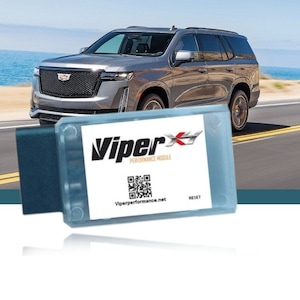 May include: A Viper Performance Module with a blue and white casing. The module has a black connector on the left side and a white label with the Viper logo, the text "Performance Module", a QR code, and the website "Viperperformance.net". The module also has a "RESET" button on the right side.