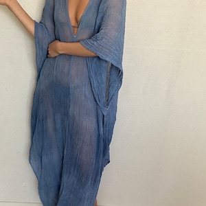 May include: A light blue sheer maxi dress with a deep V-neckline and long, flowing sleeves.
