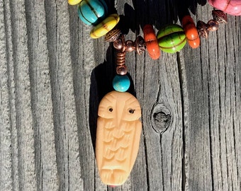 Multi colored, various shaped & size, semi-precious stone, copper/silver bracelet on a stretch band with a carved bone owl.