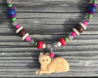Carved bone cat, multi colored howlite and silver bead necklace.