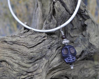Sterling silver bangle bracelet with Howlite skull bead. These are great for layering with other bangle bracelets.