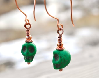 Copper dangle earrings with green Howlite skull beads.